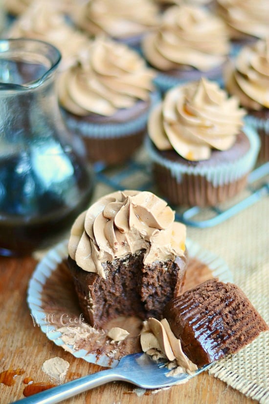 Bourbon Chocolate Cupcakes one with a bit on a fork on a wood cutting board 