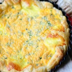 above view of four cheese breakfast souffle in pastry in a baking tin on a white and red cloth on wood table