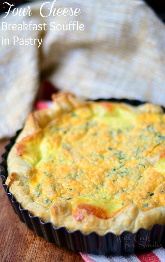 Four Cheese Souffle baked in flaky puff pastry with some fresh herbs on top in a tart pan 
