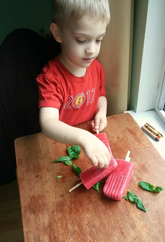 child with putting mint on the pops 