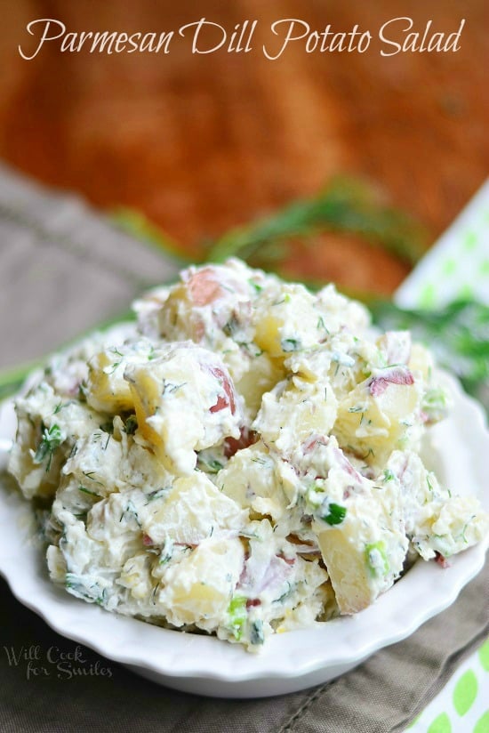 Parmesan Herb Potato Salad with red potatoes, herbs, and a mayonnaise based sauce in a white bowl 