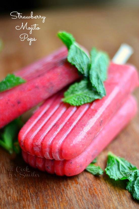 Strawberry Mojito Pops staked on a cutting board with mint 