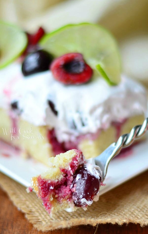 Cherry Limeade Poke Cake on a plate with a bite on a fork 