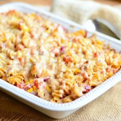 white baking casserole dish with cooked off BBQ ranch chicken casserole on a brown burlap placmat on brown table