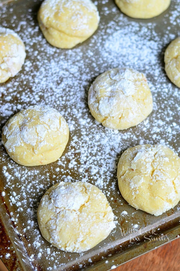 above view of banana pudding chewy cookies in baking tray on wood table covered in powdered sugar