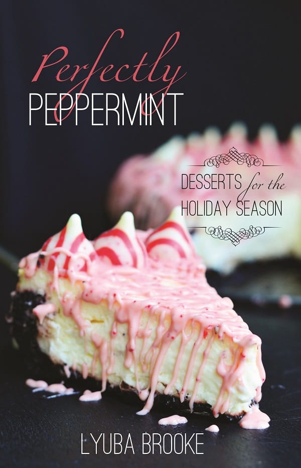 Peppermint cheesecake with peppermint kisses around the outside with peppermint and white chocolate dripped over the top 