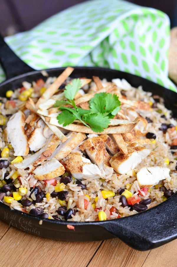 Chicken, rice, black beans, and corn in a cast iron pan with cilantro on top 