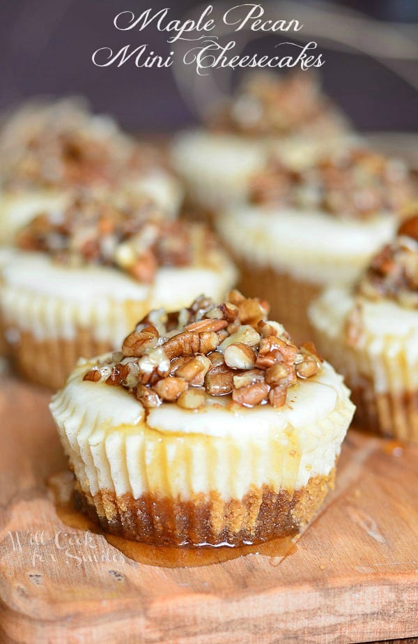 Maple Pecan Mini Cheesecakes with maple syrup and pecans on a cutting board 