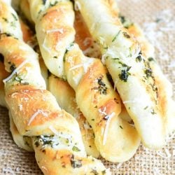 above view of homemade paresan garlic herb breadsticks on a tan placemat