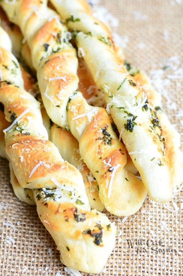 Homemade Parmesan Garlic & Herb Breadsticks on a table clothe 