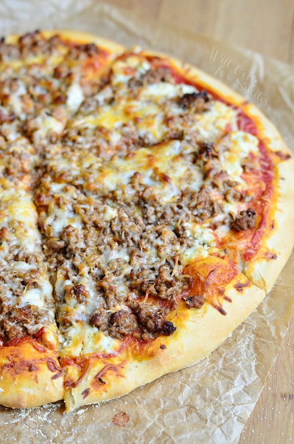 view from above of homemade lasagna pizza on wax paper and wooden table