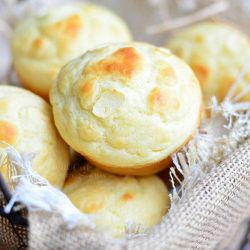 lined basket with roasted garlic dinner muffins piled in as viewd from above.