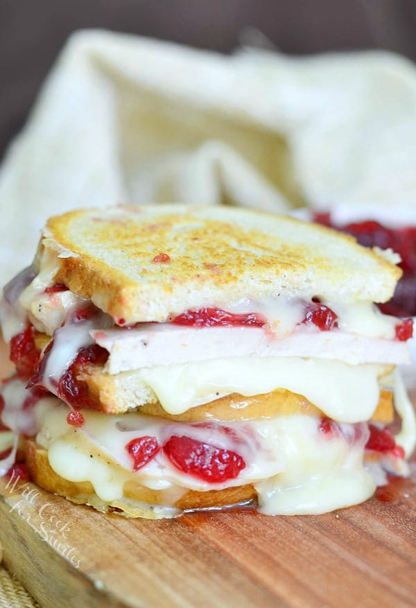 Turkey Cranberry Brie Grilled Cheese cut in half on a cutting board 