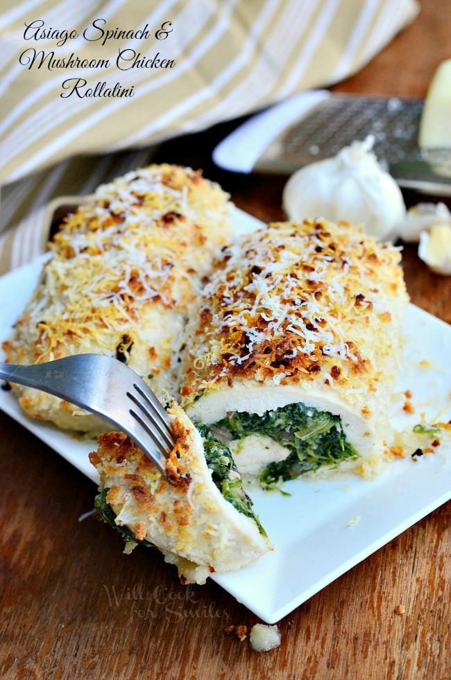 Asiago Spinach & Mushroom Chicken Rollatini on a plate with a fork with a piece on it on a white plate 