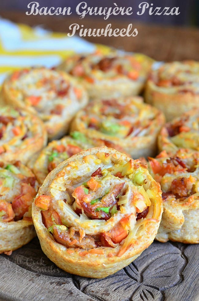 Bacon Gruyère Pizza Pinwheels stacked up on a cutting board 