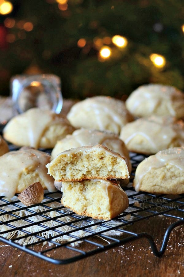 Eggnog Cookies with Eggnog Glaze on a cooling rack with one cookie cut in half and stacked on top of each other 