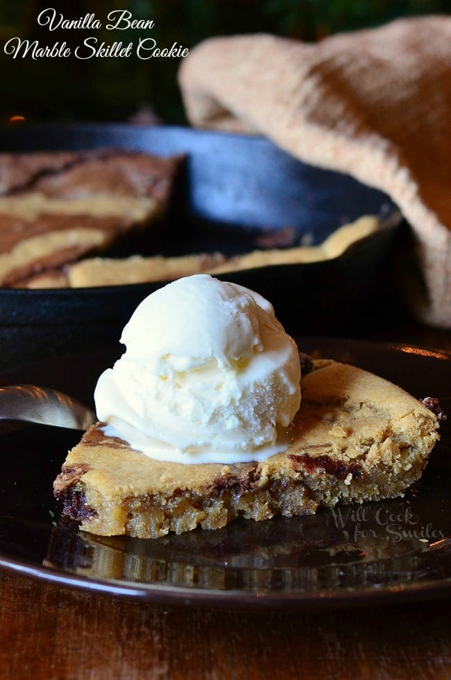 Skillet Cookie slice on a table with vanilla ice cream on top 