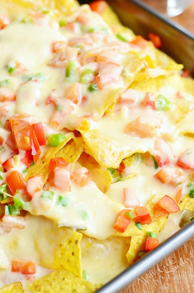 Nachos with Veggies and Cheese Sauce over it with tomato and avocado 
