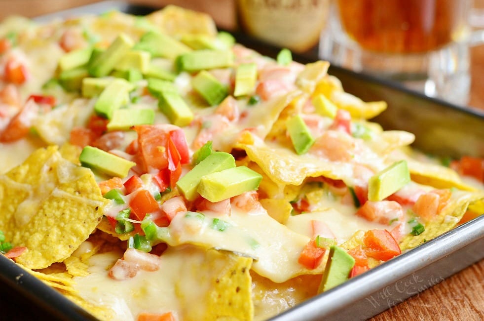 Nachos with Veggies and Cheese Sauce over it with tomato and avocado 