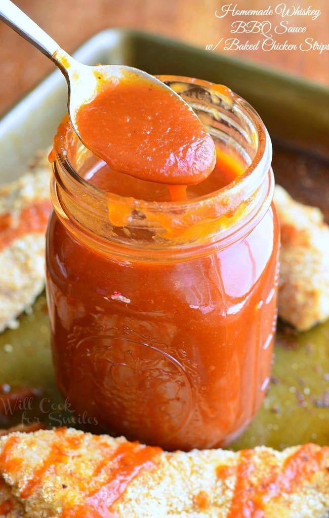 Homemade Whiskey BBQ Sauce in a mason jar with a spoon scooping some out 