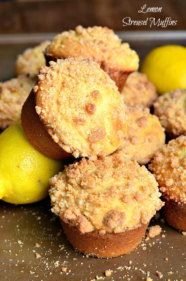 Lemon Streusel Muffins on a table with lemons around it 