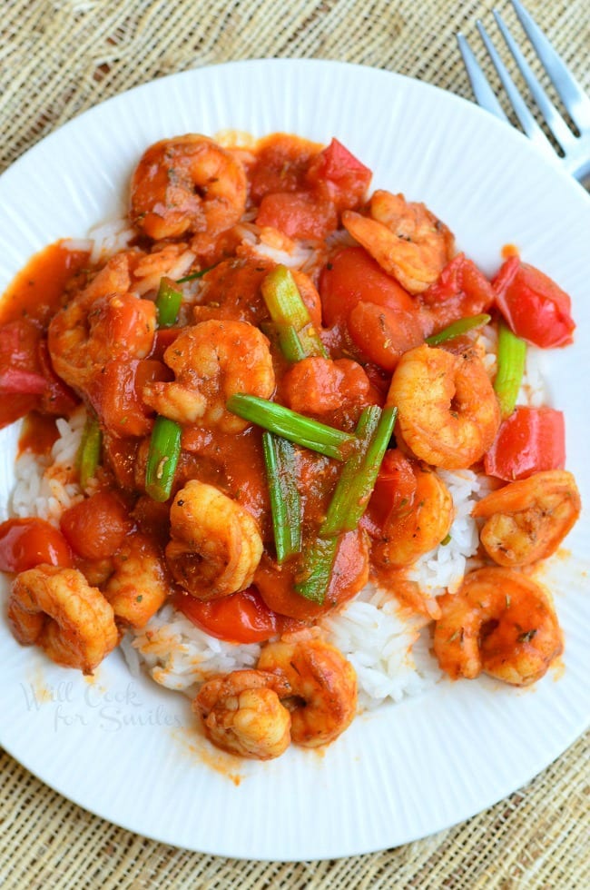 top view of Cajun Shrimp over Rice on a plate with green onions on top