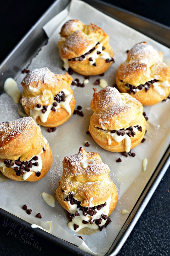 top view photo of Cannoli Choux Pastry (Cream Puffs) with chocolate chips in the middle on a baking sheet 