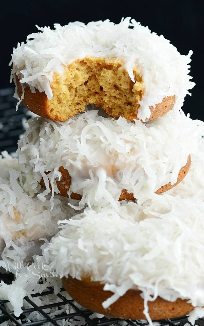 Coconut Donuts stacked on top of each other on cooling rack 