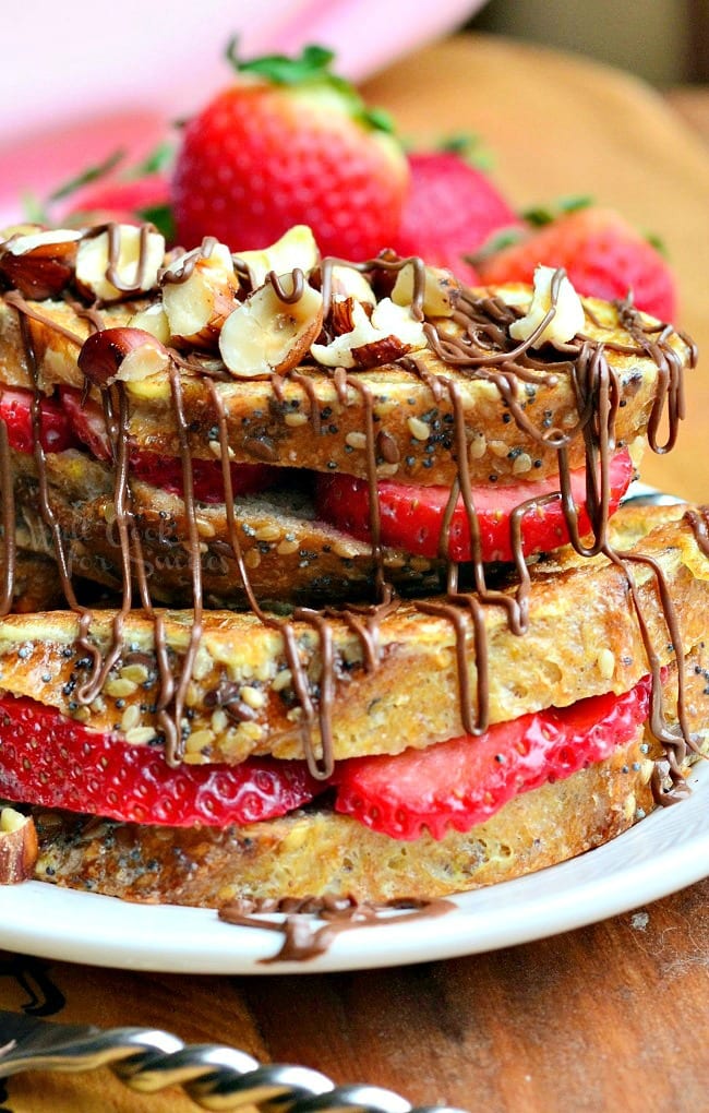 Fruit Filled Hazelnut French Toast with strawberries stacked up on a white plate 