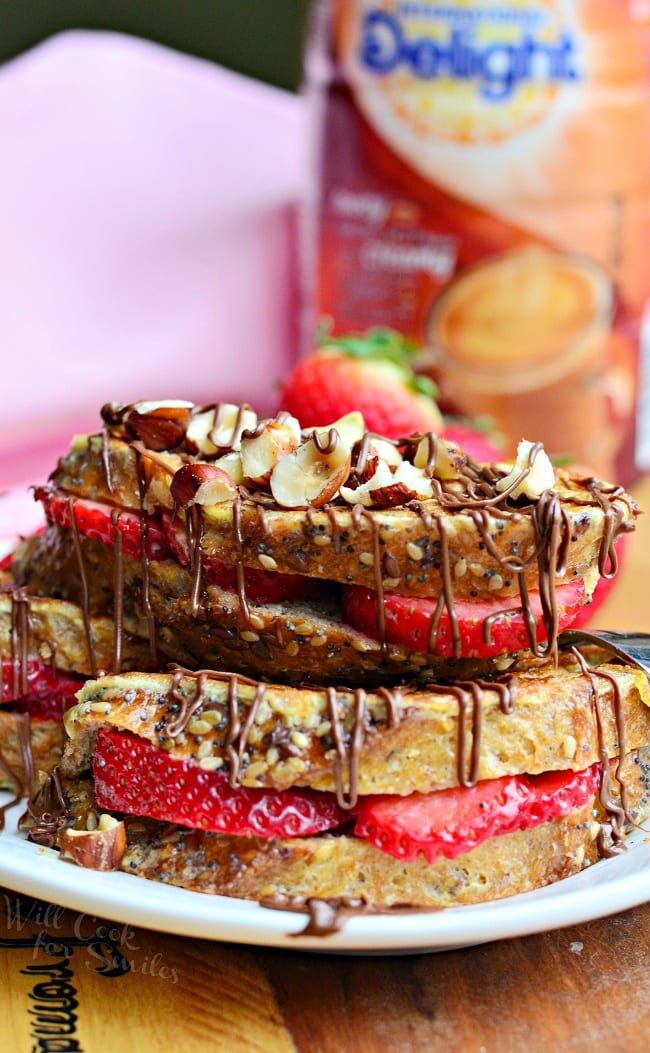 Fruit Filled Hazelnut French Toast with strawberries stacked up on a white plate 