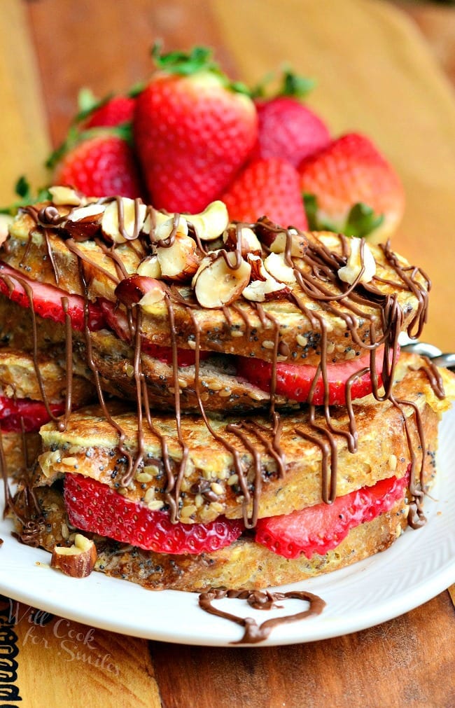 Fruit Filled Hazelnut French Toast with strawberries stacked up on a white plate 