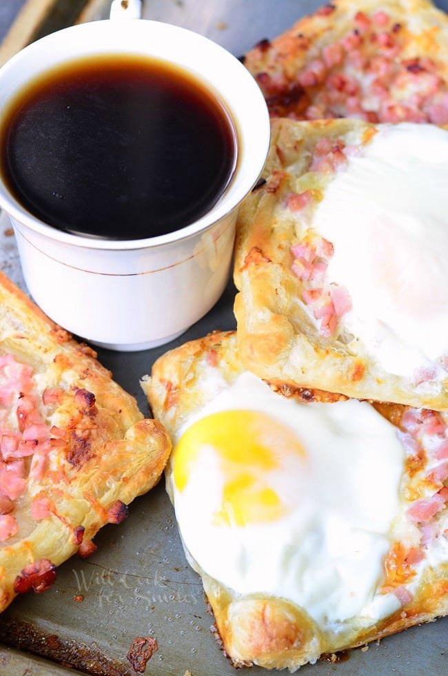 top view Ham, Egg & Cheese Breakfast Pastry on a baking dish with a cup of coffee in a white coffee cup