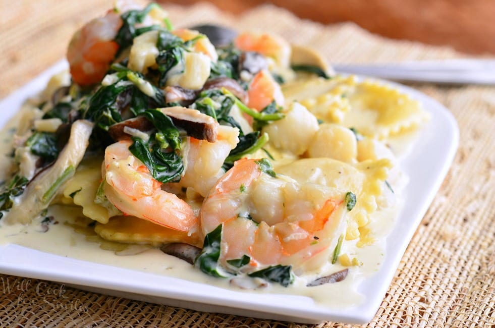 Ravioli with Seafood, Spinach & Mushrooms on a white plate 