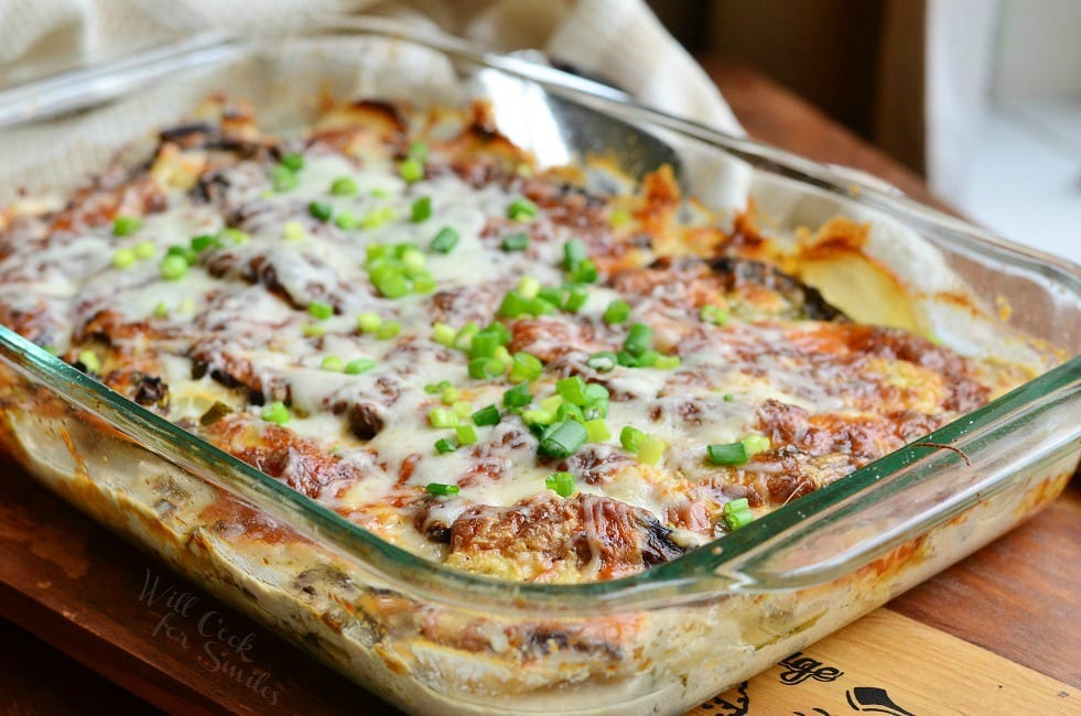 Scalloped Potatoes Au Gratin with green onions on top in a glass baking dish 