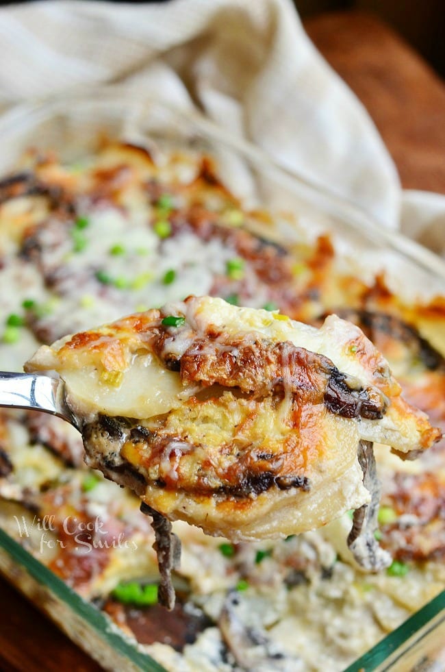 Scalloped Potatoes being lifted out of a pan with a spoon 