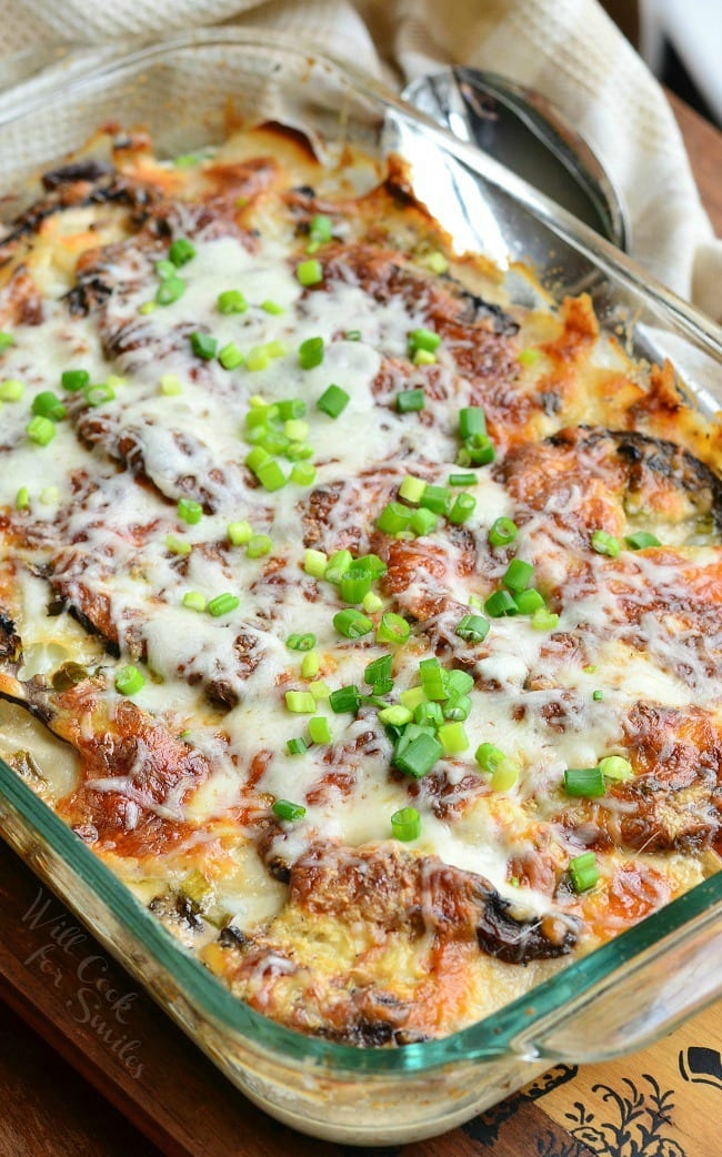 Scalloped Potatoes & Portobello Au Gratin in a baking dish with a spoon to the right of the dish 