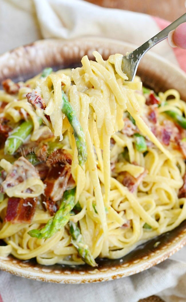Bacon Asparagus Pasta Carbonara on a plate with a fork with pasta on it 