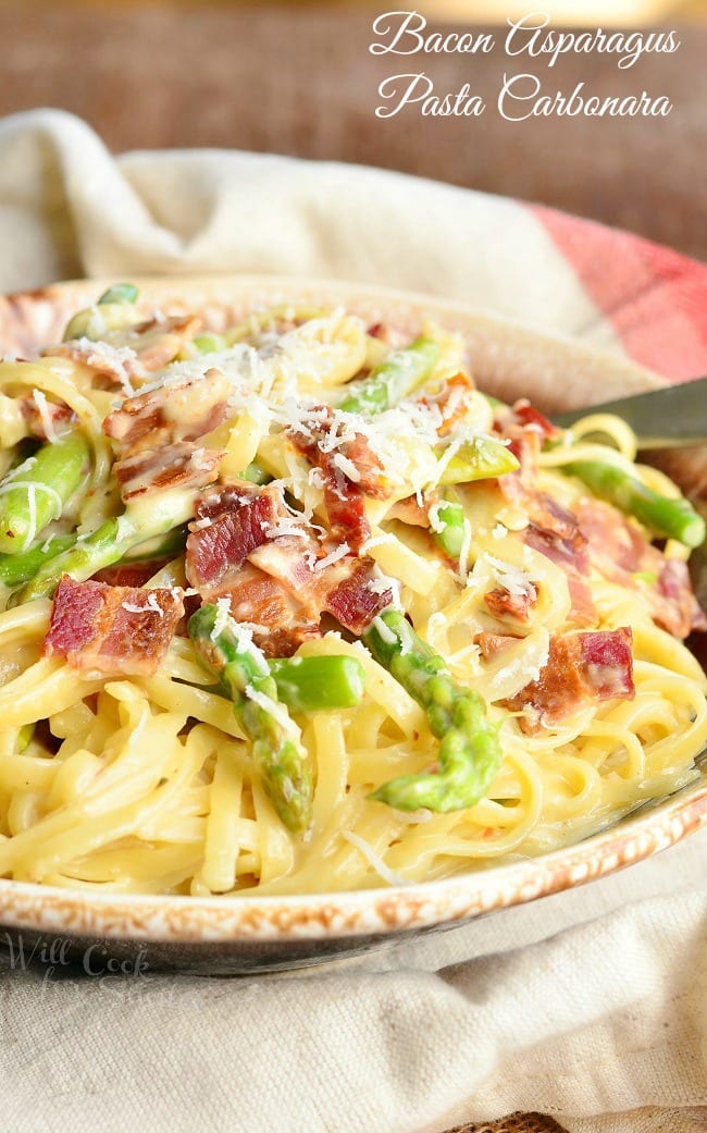 Bacon Asparagus Pasta Carbonara in a bowl. Noodles are topped with asparagus, bacon, and grated cheese.