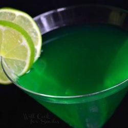 view from above of a martini glass filled with lime martini and garnished with lime garnishes