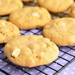 Sweet and salty white chocolate chip peanut butter cookies on a cooling rack on top of blue cloth