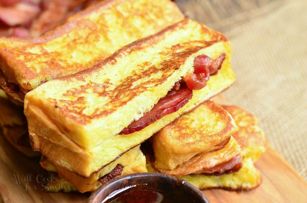 horizontal view of stacked french toast sticks with bacon in the middle