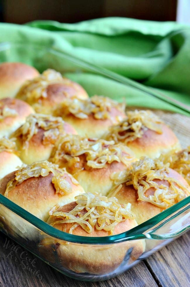 Caramelized Onion Dinner Rolls with onions on top in a glass backing dish 