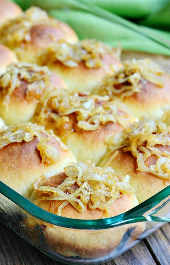 Caramelized Onion Dinner Rolls with onions on top in a glass backing dish 