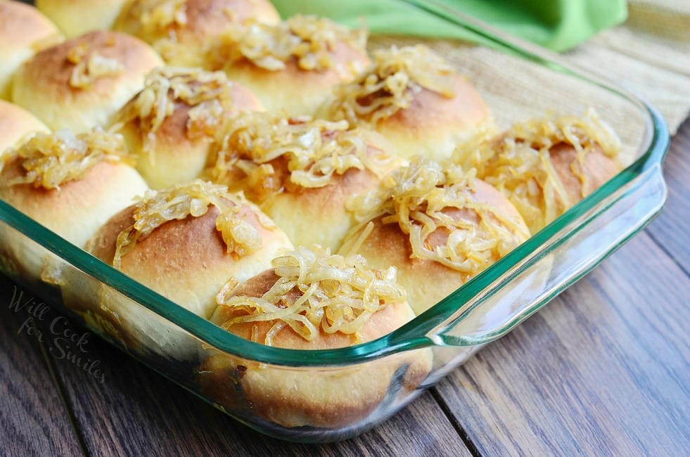 Caramelized Onion Dinner Rolls with onions on top in a glass backing dish 