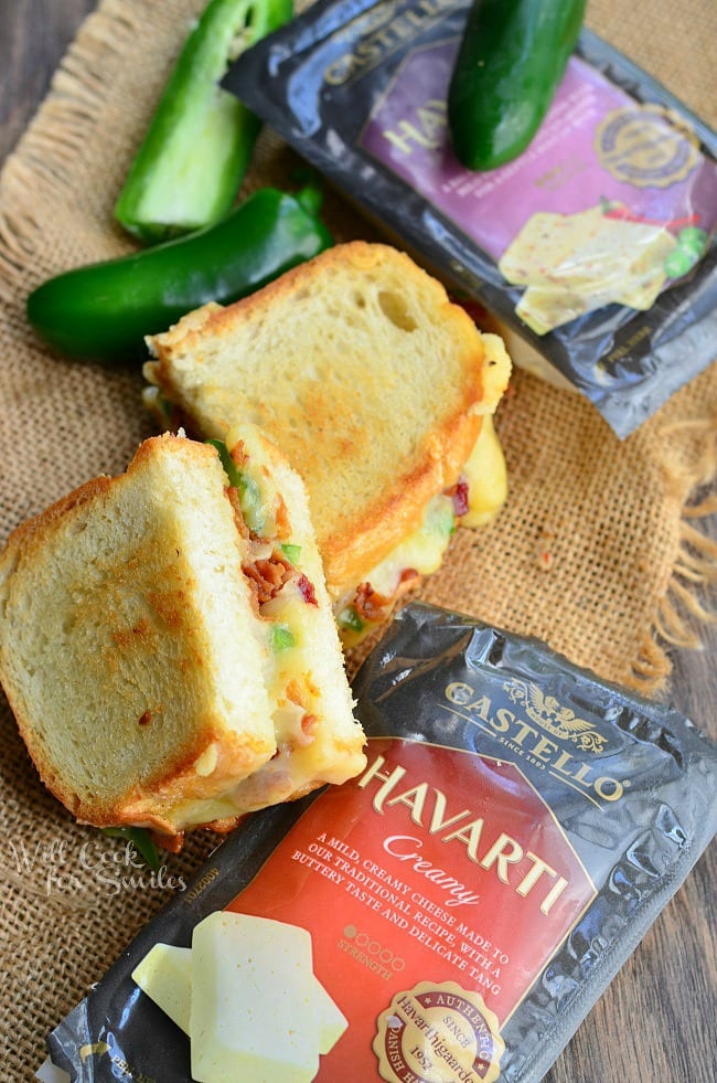 Jalapeno Popper Grilled Cheese loaded with gooey cheese, jalapenos and bacon cut in half with a jalapenos to the side  and packages of cheese 