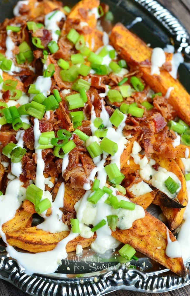  Loaded Sweet Potato Wedges on  a plate with bacon, sour cream, and green onions