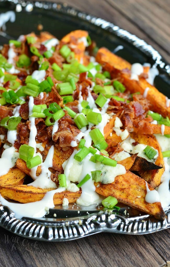 a silver platter with a side of loaded sweet potato wedges