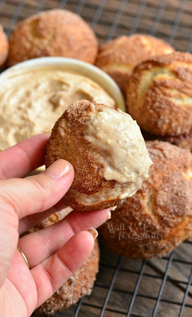 holding a Snickerdoodle Pretzel Puff with the rest in the background on a cooling rack 