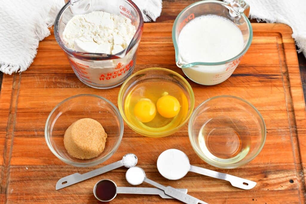 The ingredients for buttermilk pancakes are spread out on a wooden surface. 