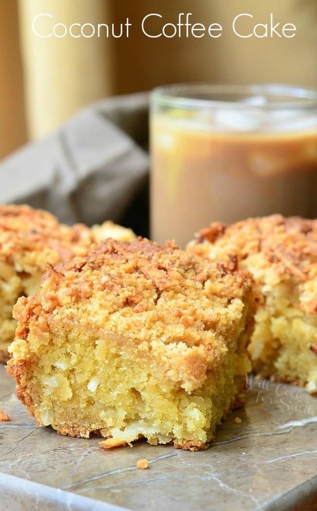 Coconut Coffee Cake slices on a table with coffee in the background 